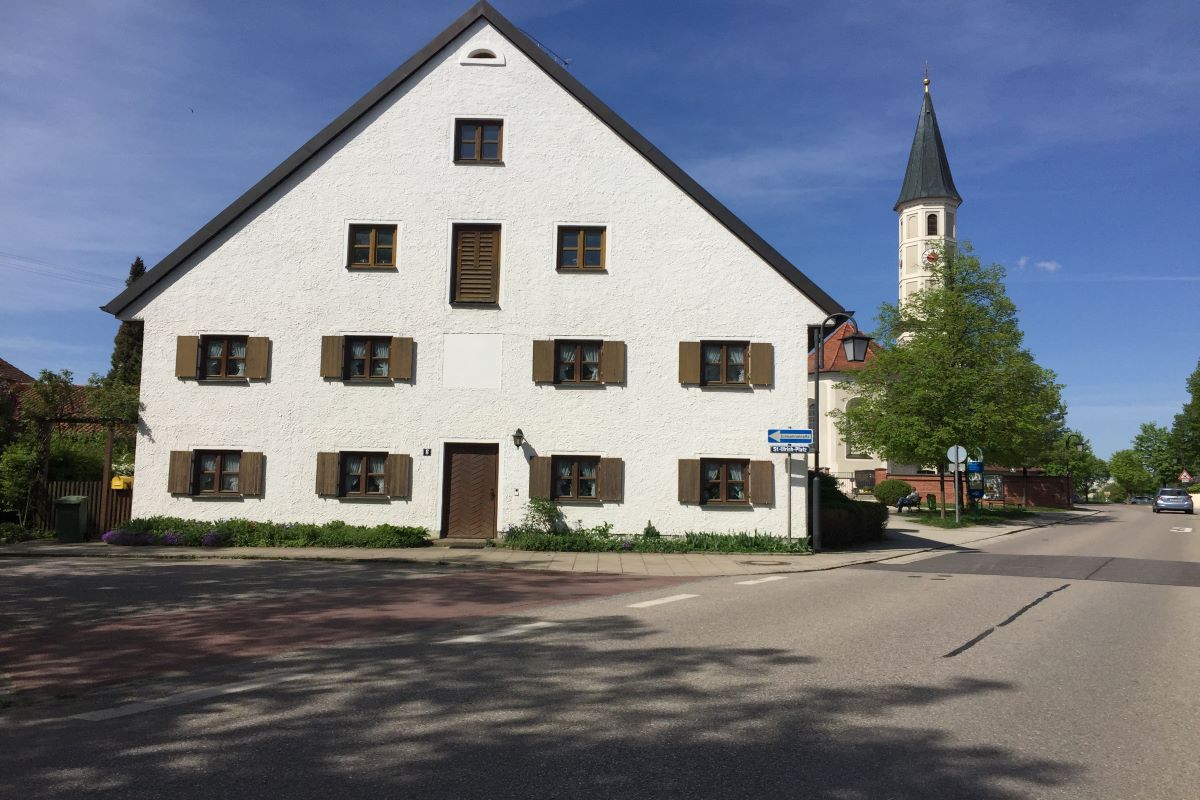 Das Anwesen Mesner/Kotter mit der Kirche St. Ulrich im Hintergrund.