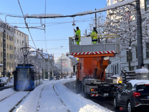 Betriebseinstellung bei Bus und Tram und ungenügende Schneeräumung Die Oberleitungen der Trambahn werden von Eis und Schnee befreit