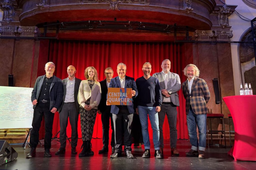 Initiative: Gruppenfoto der Namensverkündung im Deutschen Theater: „Vertre- terinnen und Vertreter der Initiative bei der öffentlichen Vorstellung des Namens Central Quartier im Dezember 2025.“